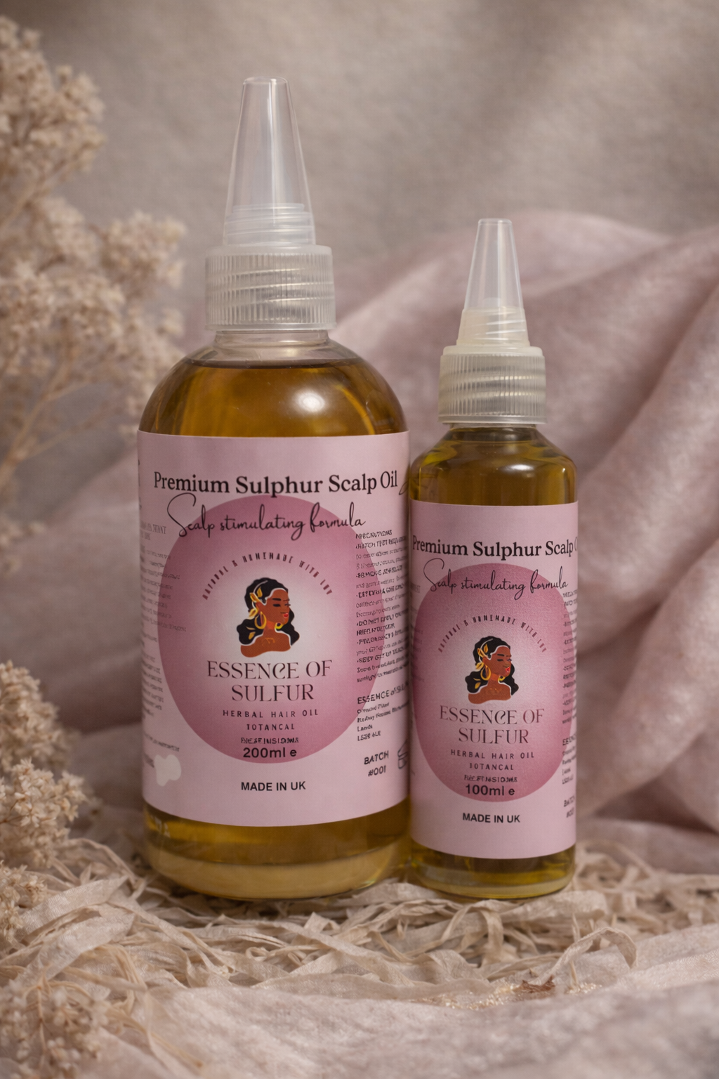 Two bottles of 'Essence of Sulphur' scalp oil, 100ml sand 200ml on a neutral background
